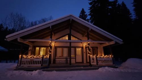 eine Hütte mit Weihnachtslichtern im Schnee in der Nacht in der Unterkunft Villa Aurora, Himos in Jämsä