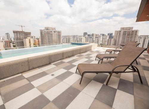 a balcony with chairs and a swimming pool on a building at Metro Brooklin - Be Urban in Sao Paulo