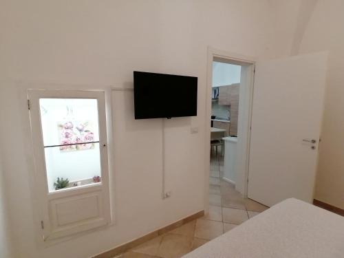 Habitación con ventana y TV en la pared. en ELISEA HOUSE MARIO PAGANO, en Oria