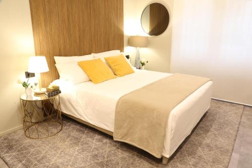 a bedroom with a large white bed with yellow pillows at Meyland suites centro in Milan