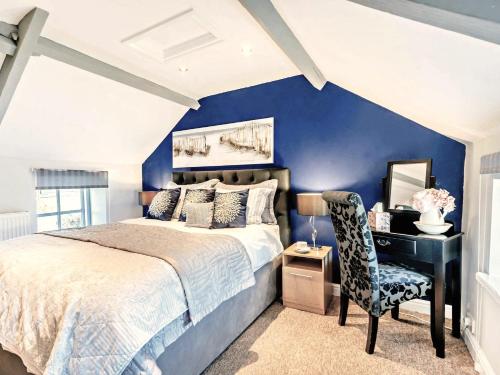 1 dormitorio con pared azul, cama y escritorio en 1 Bed in Porthcawl 42314 en Brynmenin