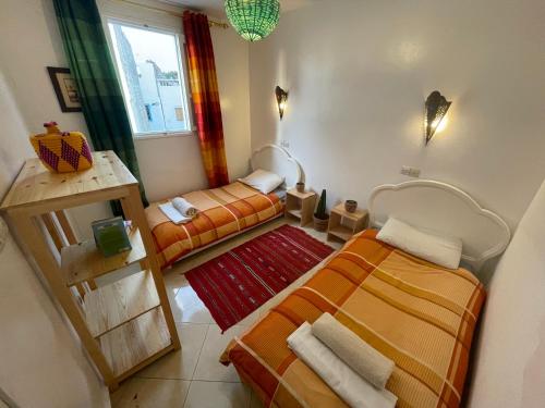 a small room with two beds and a couch at Cozy Surf House in Taghazout