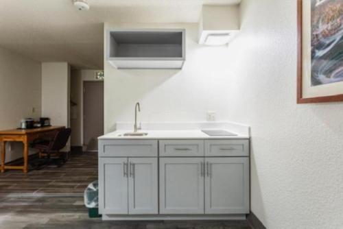 a kitchen with white cabinets and a sink at Lancaster Inn & Suites in Manheim