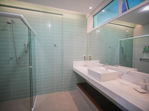 a bathroom with a sink and a glass shower at Hotel Velas do Engenho in Ilhabela