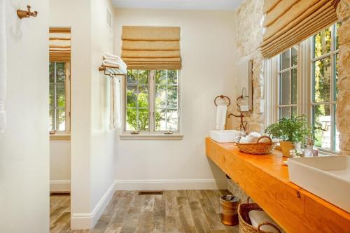 uma casa de banho com um lavatório e 2 janelas em Luxury Warm Springs River Home em Ketchum