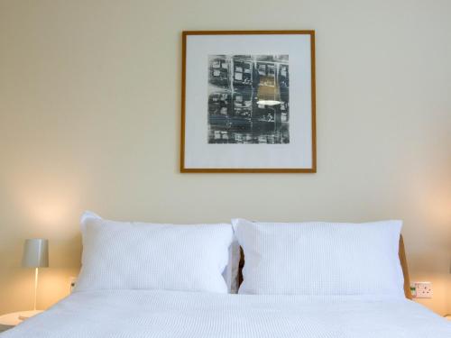 1 cama con 2 almohadas blancas y una foto en la pared en 3 Bed in Camber BT044, en Camber
