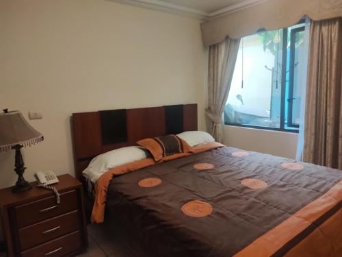 a bedroom with a large bed and a telephone at Hotel Jardines del Rio in Loja