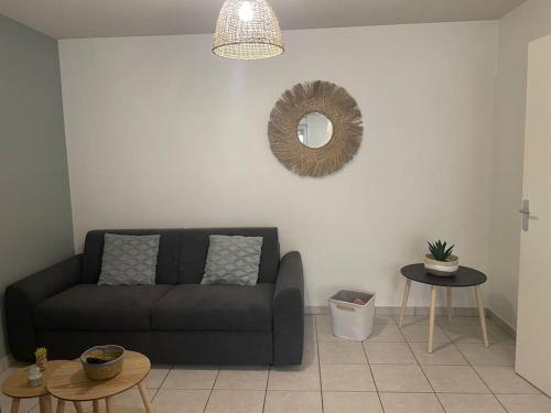 a living room with a couch and a mirror at Le Central-Proche Gare et Genève in Annemasse