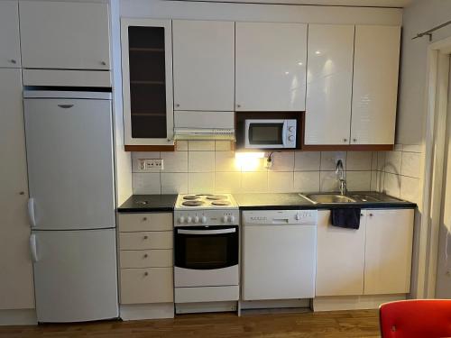 a kitchen with white appliances and white cabinets at AaltoStudio Alajärvi-Center in Alajärvi