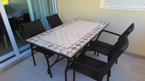 mesa de comedor con 4 sillas y mantel en Tróia Beach Apartment, en Carvalhal