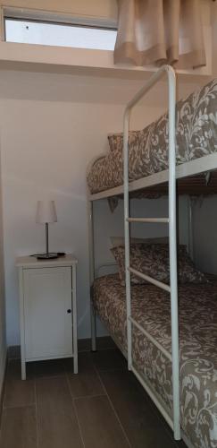 1 dormitorio con 2 literas y mesita de noche en Tróia Beach Apartment, en Carvalhal