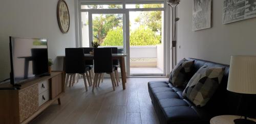 sala de estar con sofá y mesa en Tróia Beach Apartment, en Carvalhal