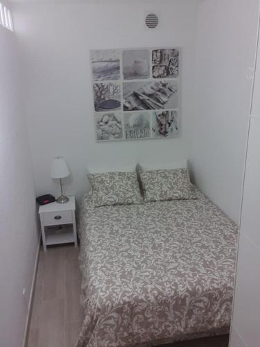 Habitación pequeña con cama y mesita de noche en Tróia Beach Apartment, en Carvalhal
