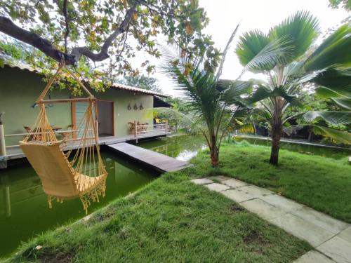 a room with a hammock in the yard of a house at Chalés da Cris in Fortim