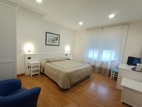 a bedroom with a bed and a table and a chair at Hotel L'Isola in Santa Marinella