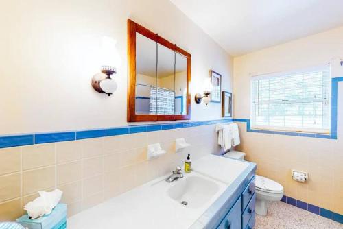 La salle de bains est pourvue d'un lavabo, d'un miroir et de toilettes. dans l'établissement Private 3 bedroom waterfront Villa with pool, à Clearwater Beach