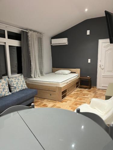 ein kleines Zimmer mit einem Bett und einem Sofa in der Unterkunft Sofita in Néa Michanióna
