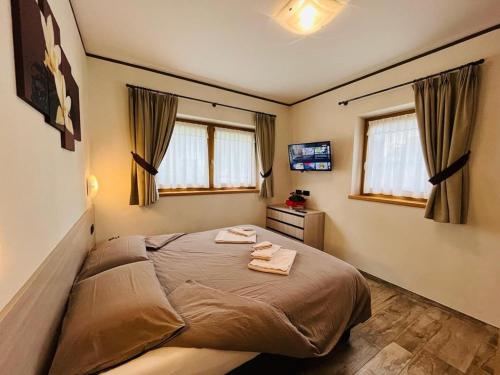 een slaapkamer met een bed met twee handdoeken erop bij Chalet Sunshine in Livigno