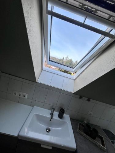 a bathroom with a sink and a window at FEWO "Rabennest " Gemütliche Wohnung nahe Rabensteinklinikum - kein separates Schlafzimmer, Studiowohnung in Chemnitz