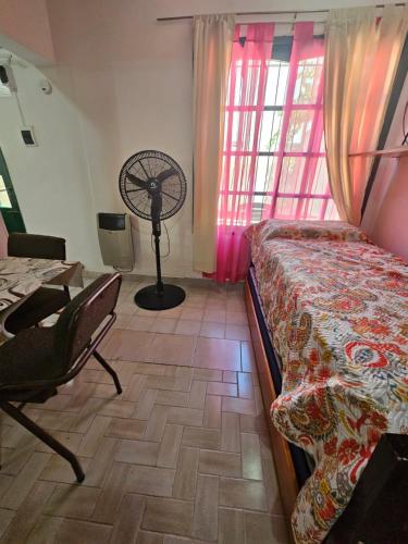 1 dormitorio con 1 cama, escritorio y ventilador en Monoambiente Centrico en Calle Pampa - Neuquén en Neuquén