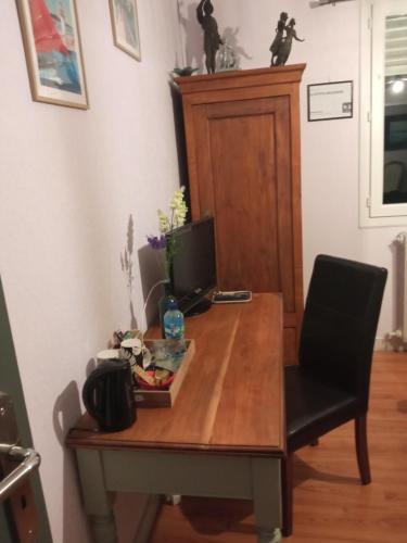 a desk with a computer on it with a chair at LA PETITE MEUNIERE in Tramain