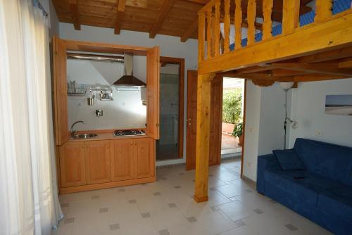 sala de estar con sofá azul y cocina en Mini appartamento il Villaggio, en Valmontone