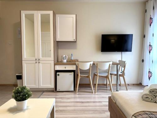 a living room with a kitchen and a table with chairs at Willa Uliaszówka in Szczawnica