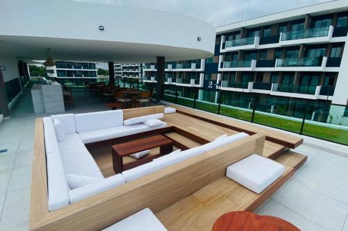 a living room with a white couch on a building at Studio de Luxo em Muro Alto - Makia Beach A209 in Porto De Galinhas