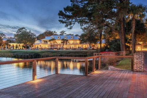 a house with a wooden deck next to a body of water at Montage Palmetto Bluff in Bluffton