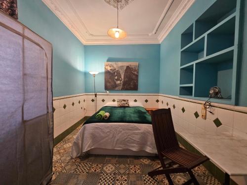 - une chambre avec un lit et une chaise dans l'établissement Fabrica de Sueños, à Gandía