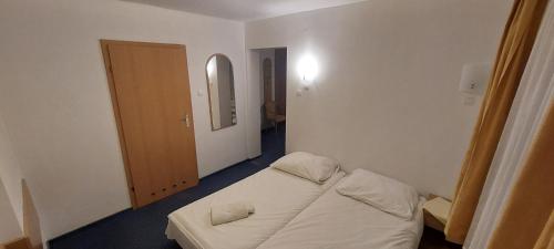 a small room with a bed and a mirror at Lila Medical SPA in Ciechocinek