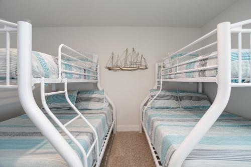 two bunk beds in a room with a sailboat on the wall at Mins to the Beach/King Beds/Arcade-Snowbird Deals! in Perdido Key