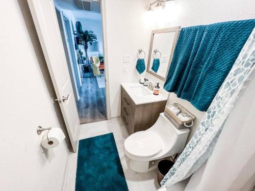 a bathroom with a toilet and a sink and a mirror at Moody Gardens Oasis (Unit 8) in Galveston