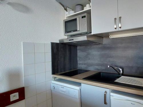 une cuisine avec un évier et un micro-ondes dans l'établissement Appartement 2 pièces avec piscine, proche télécabine aux Arcs 1800 - FR-1-411-840, à Bourg-Saint-Maurice