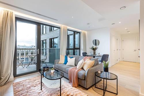 a living room with a couch and glass tables at Chic and Sleek Oasis in London