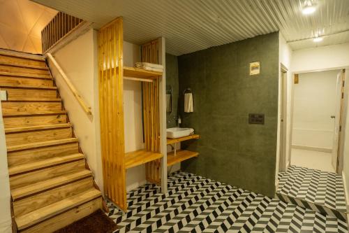 Pokój z klatką schodową i łazienką z umywalką w obiekcie SaffronStays Big Dipper w mieście Bir