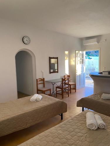 a bedroom with two beds and a table and chairs at Ios Village View in Ios Chora