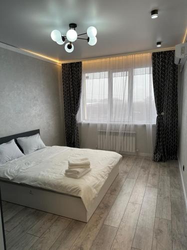 a bedroom with a white bed and a window at Аэропорт Алтын сити in Almaty