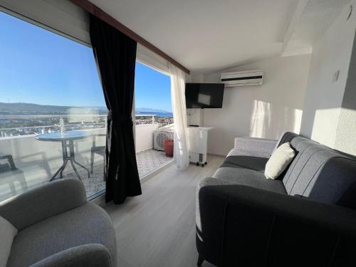 a living room with a couch and a table with a view at Tepe Hotel in Alacati