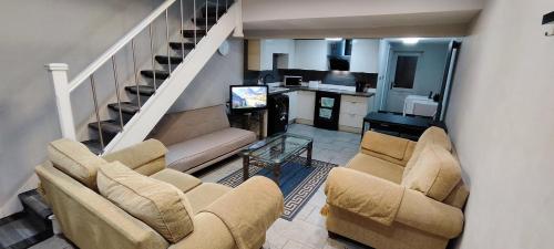 a living room with a couch and chairs and a staircase at A Whole Townhouse to you in Distington