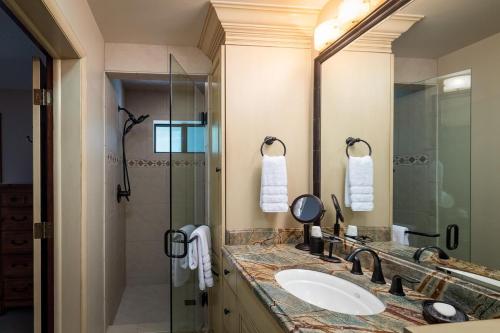 uma casa de banho com um lavatório e uma cabina de duche em vidro. em Creek Front Duplex Close to Lifts with Hot Tub em Ketchum