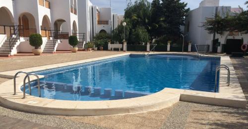 a large swimming pool in a courtyard with a building at Puerto de Mazarrón - Large 2 or 3 Bedroom House with Roof Terrace and Wonderful Sea Views in Puerto de Mazarrón