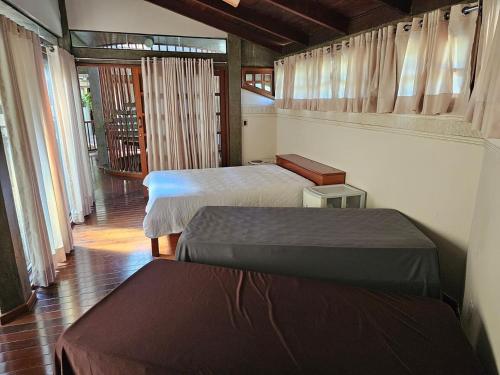 a room with two beds and a hallway with windows at Chacara com Wi-Fi e piscina em Ouro Verde De Goias in Matão