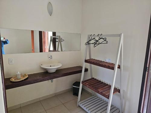 ein Bad mit einem Waschbecken und einem Spiegel in der Unterkunft Chacara com Wi-Fi e piscina em Ouro Verde De Goias in Matão