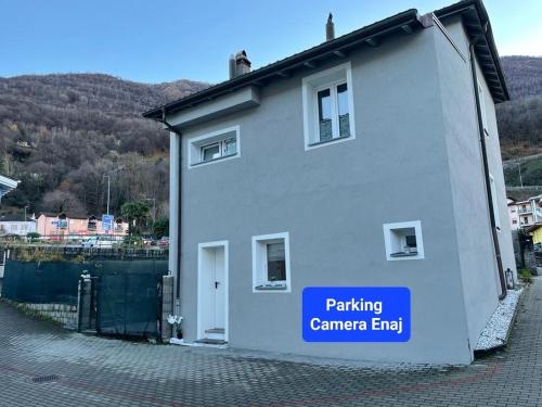 ein weißes Haus mit einem Schild, das das Ende der Parkkamera liest in der Unterkunft Camera Enaj in Cadenazzo