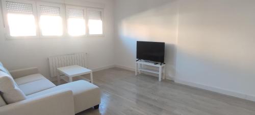 a living room with a white couch and a tv at Eco Home Alpera 1 in Alpera