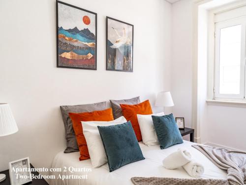 sypialnia z łóżkiem z pomarańczowymi i niebieskimi poduszkami w obiekcie Akicity Penha Tranquil w Lizbonie