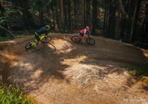 two people riding bikes on a dirt road at Residence Smržovka - Luxury House with Swimming Pool, Jacuzzi, Garden and BBQ in Jablonec nad Nisou