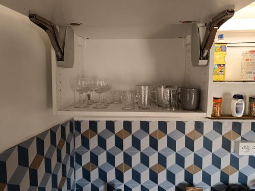 een keuken met een aanrecht met glazen op een plank bij 29 Rue Mellaise, Appartement 3 pièces in Niort