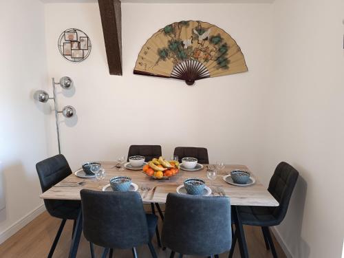 einen Tisch mit Stühlen und eine Obstschale darauf in der Unterkunft 29 Rue Mellaise, Appartement 3 pièces in Niort